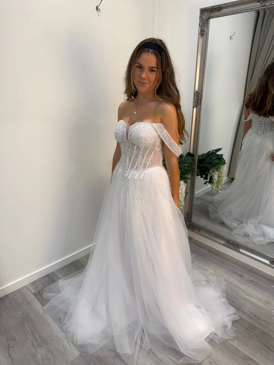 Side of the Cecile debutante dress, model smiling at the camera