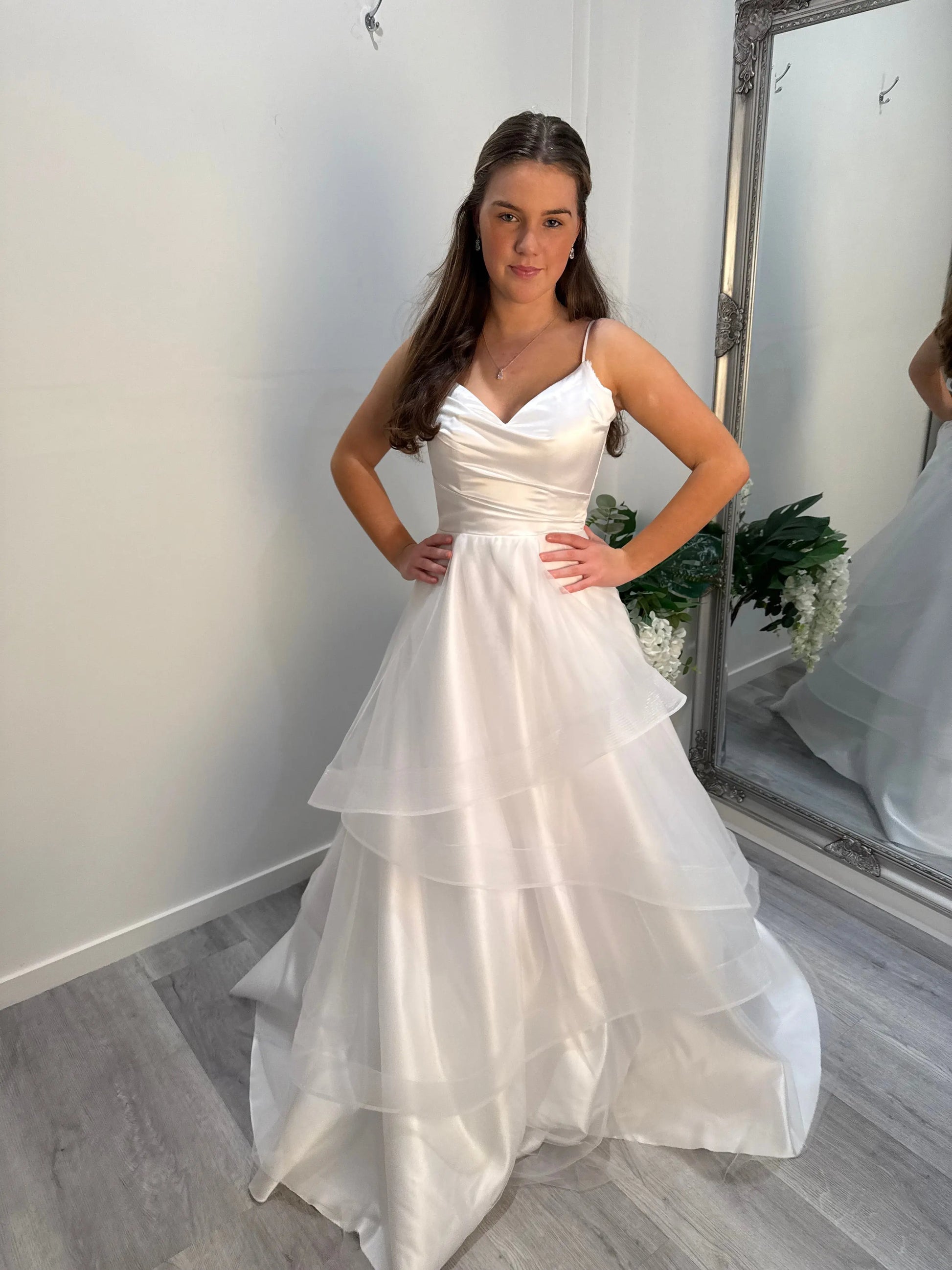 Front view of the Chloe Debutante Dress with model looking at camera, showing silky bodice and spaghetti straps