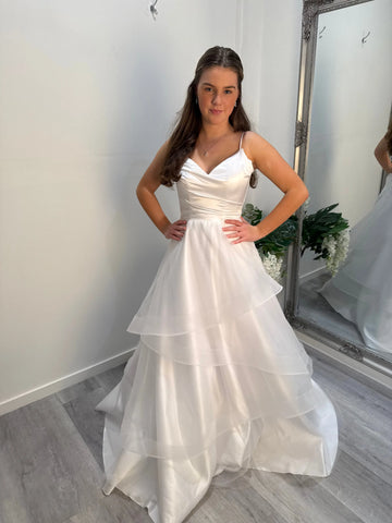 Front view of the Chloe Debutante Dress with model looking at camera, showing silky bodice and spaghetti straps