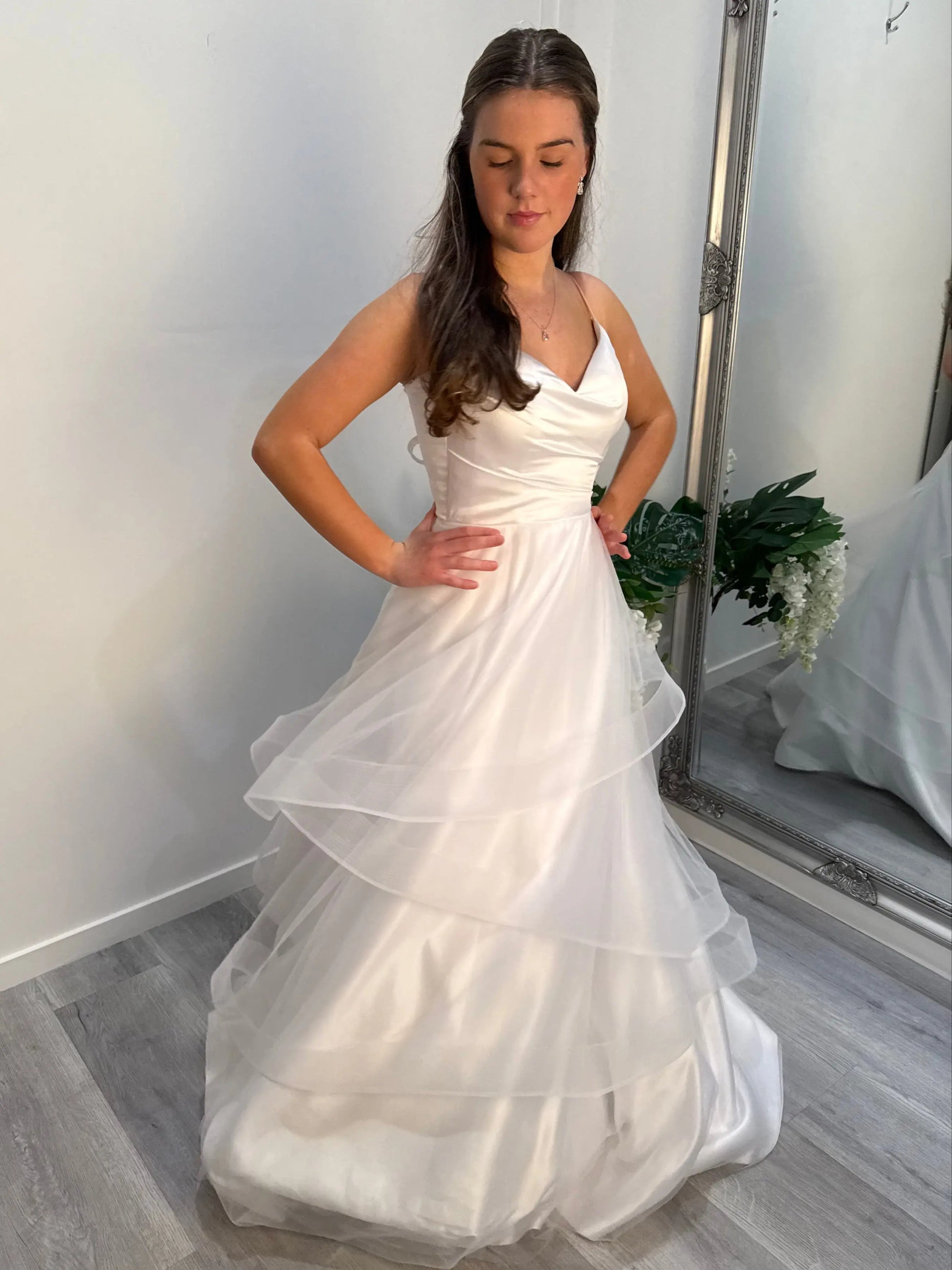 Model slightly turning to create a graceful twist in the layered skirt