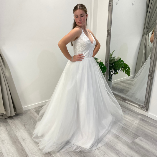 Side front view of Valentina Lace Essence Deb Dress showcasing an intricate lace bodice, delicate straps, and a flowing skirt for a graceful and feminine silhouette.