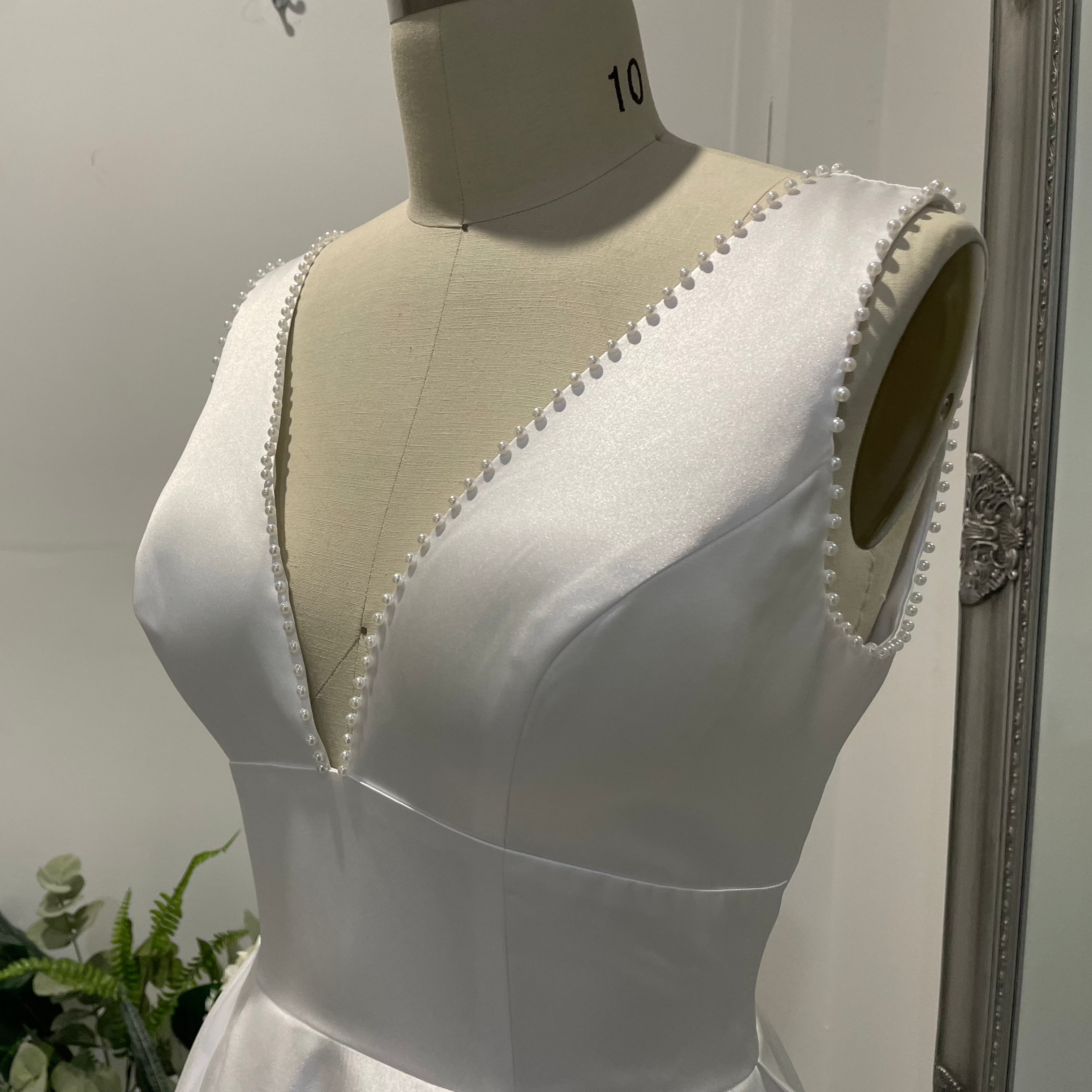 Liora Satin Whisper Deb Dress with pearl-trimmed V-neckline, satin A-line skirt, and slim straps
