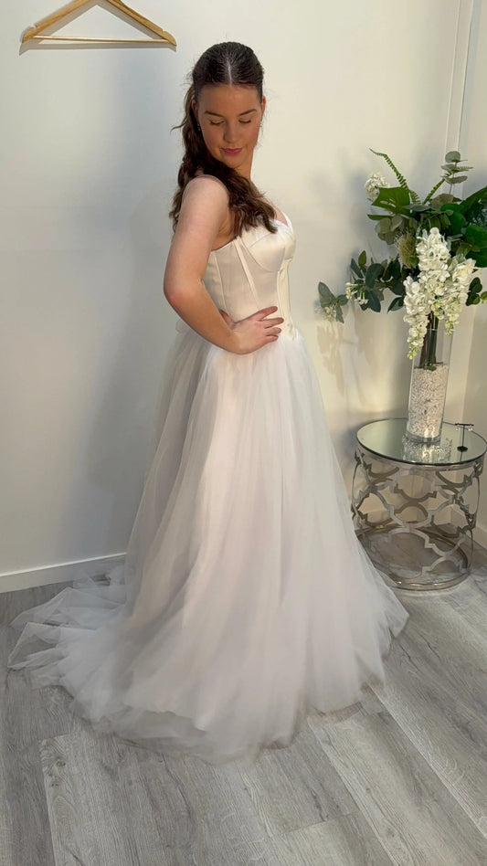 Woman in the Ivy dress showcasing the side of the dress, looking down