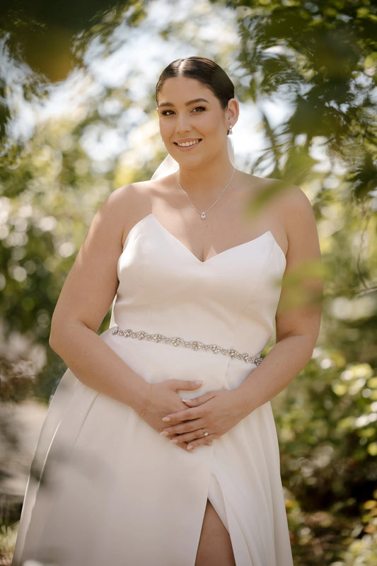 Close-up of bride in Katrin gown showing the structured strapless bodice, sweetheart neckline, and sparkly waist detail.