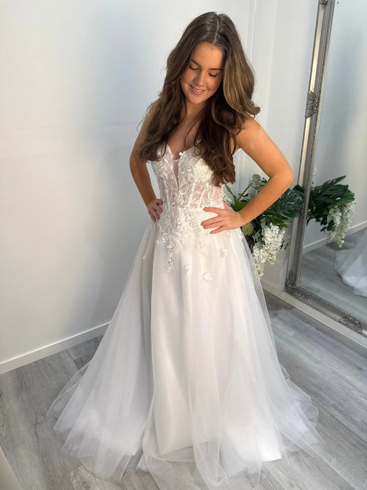 Model looking down, showcasing the lace-detailed bodice of the Kelly Debutante Dress