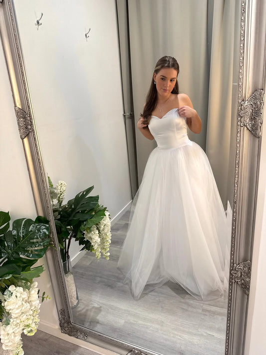 Model looking in the mirror, showcasing the front of the Lucille Debutante Dress