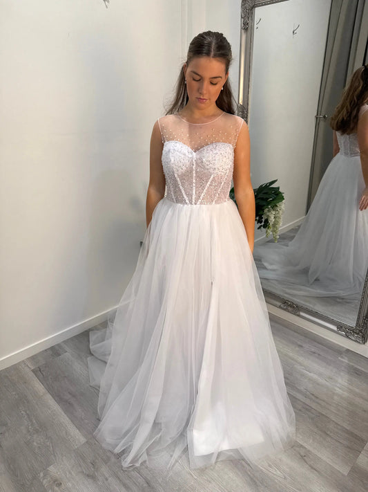 Front of the Maxine debutante dress, model looking down at the bodice