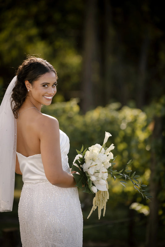 Back view of the Nina luxury wedding dress showcasing a fitted silhouette without the detachable satin overskirt, highlighting the modern sequin detail and chapel-length train.