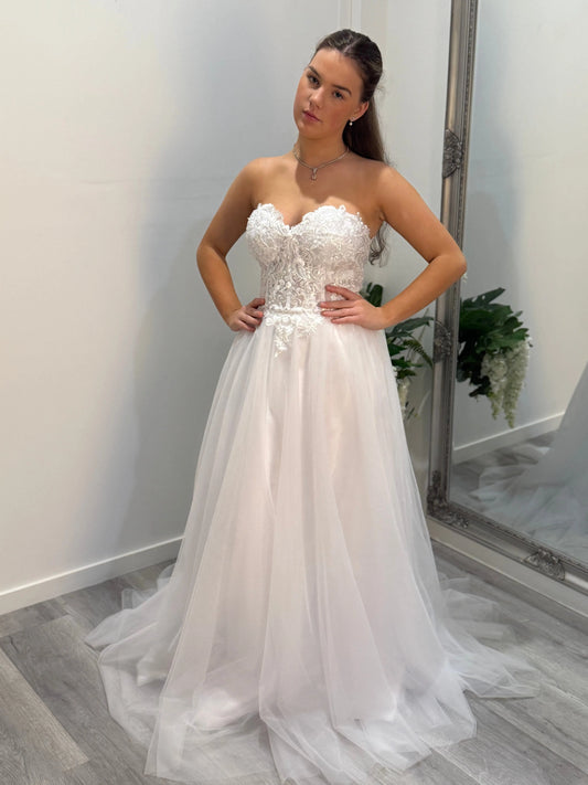 Front of Regina debutante dress, model looking toward camera with head tilted