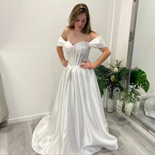 Side front view of Vallorie Debutante Dress featuring a sweetheart neckline, lace corset bodice with delicate beading, and a satin A-line skirt with pleats at the waist.