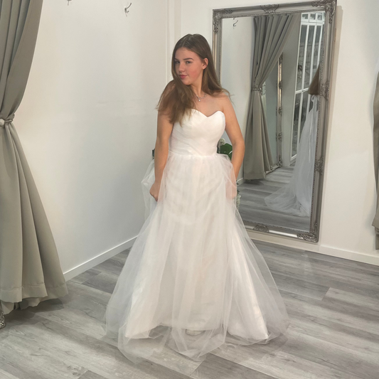 Front view of Velora Debutante Dress showcasing a sweetheart neckline with a lace corset bodice, supported by delicate straps, and an A-line satin skirt with pleats at the waist.