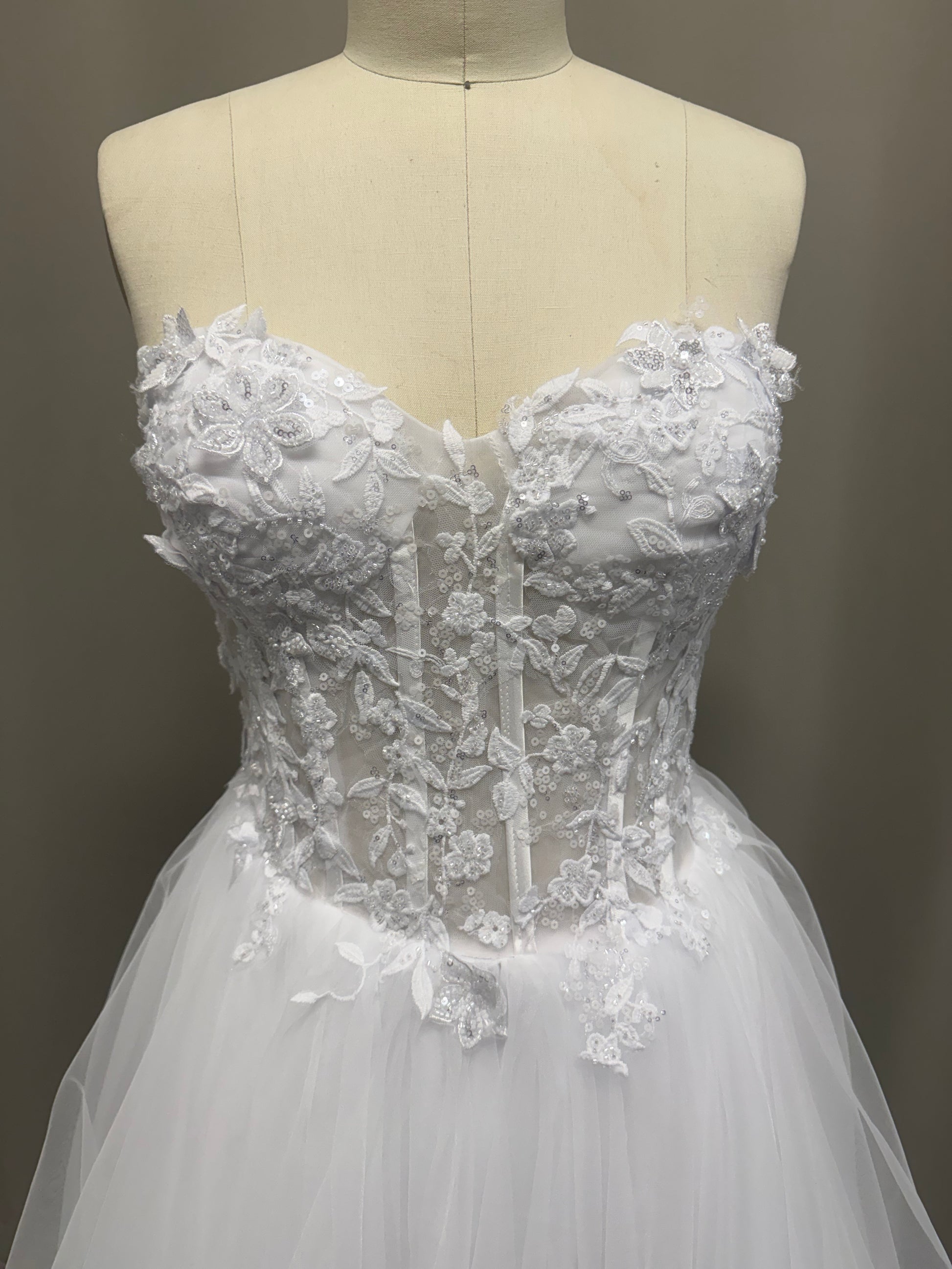 Close-up of Abby V1 sheer corset debutante dress strapless sweetheart bodice with sheer panels and floral sequin lace