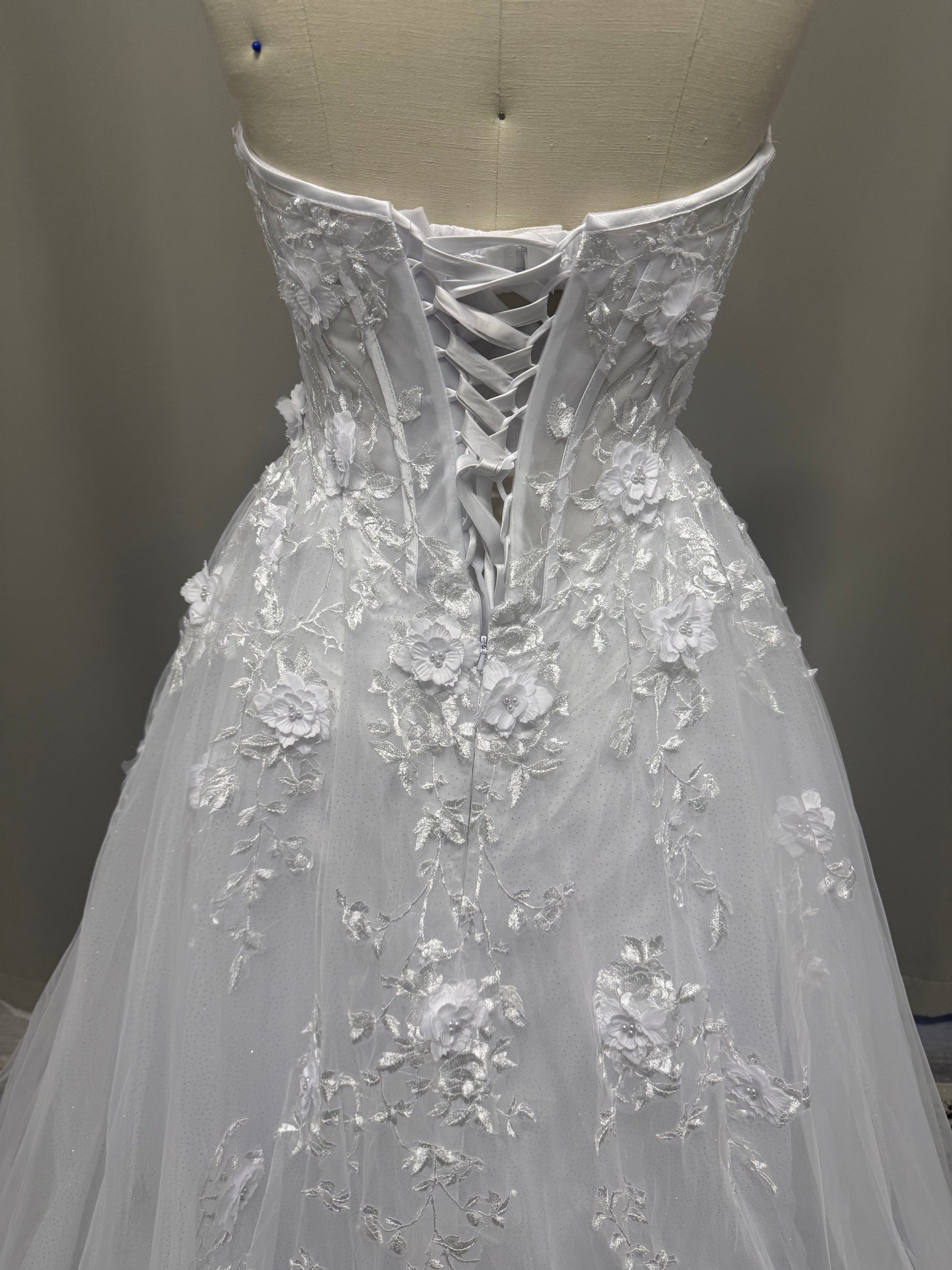 Alana V1 3D floral debutante dress back view showing lace-up corset, raised flowers and cascading lace on white tulle skirt