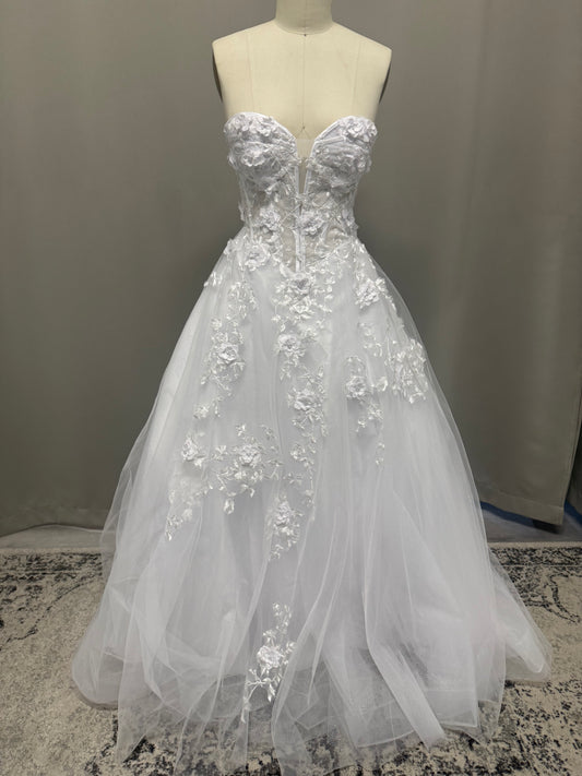 Alana V1 white 3D floral debutante dress, front view on mannequin with raised flower corset and cascading lace tulle skirt