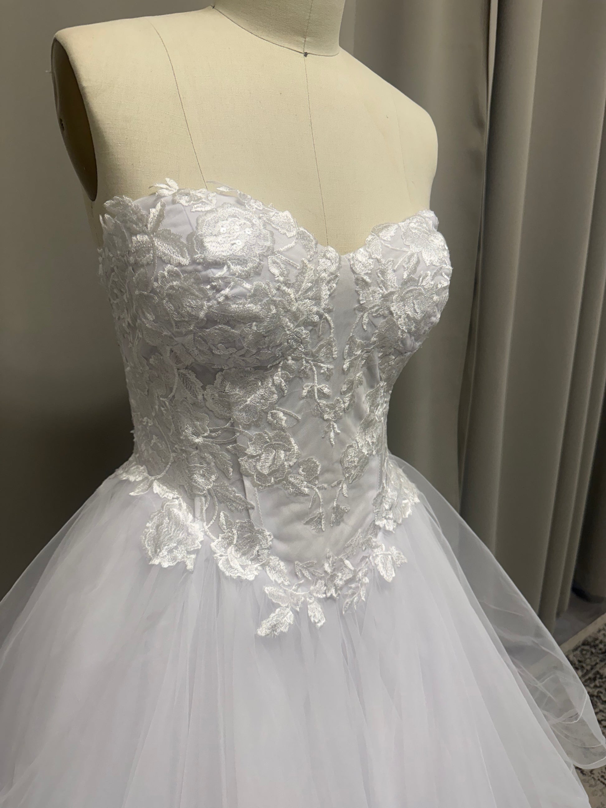 Close-up of Amaira V1 floral appliqué debutante dress strapless sweetheart bodice with floral lace appliqué