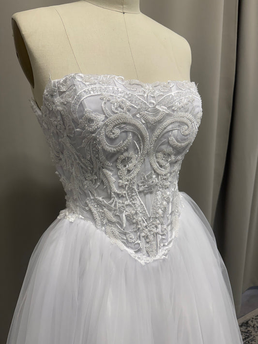 Close-up of Ava V1 scroll lace debutante dress strapless sweetheart bodice with pearl and bead detail