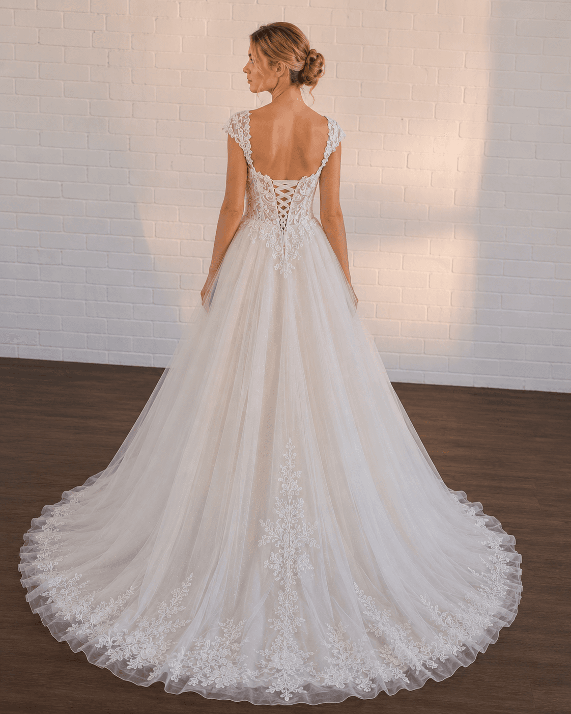 White lace A-line wedding dress with a corset back and flowing tulle skirt.
