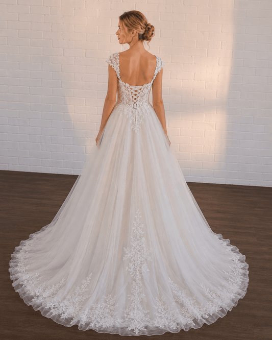 White lace A-line wedding dress with a corset back and flowing tulle skirt.