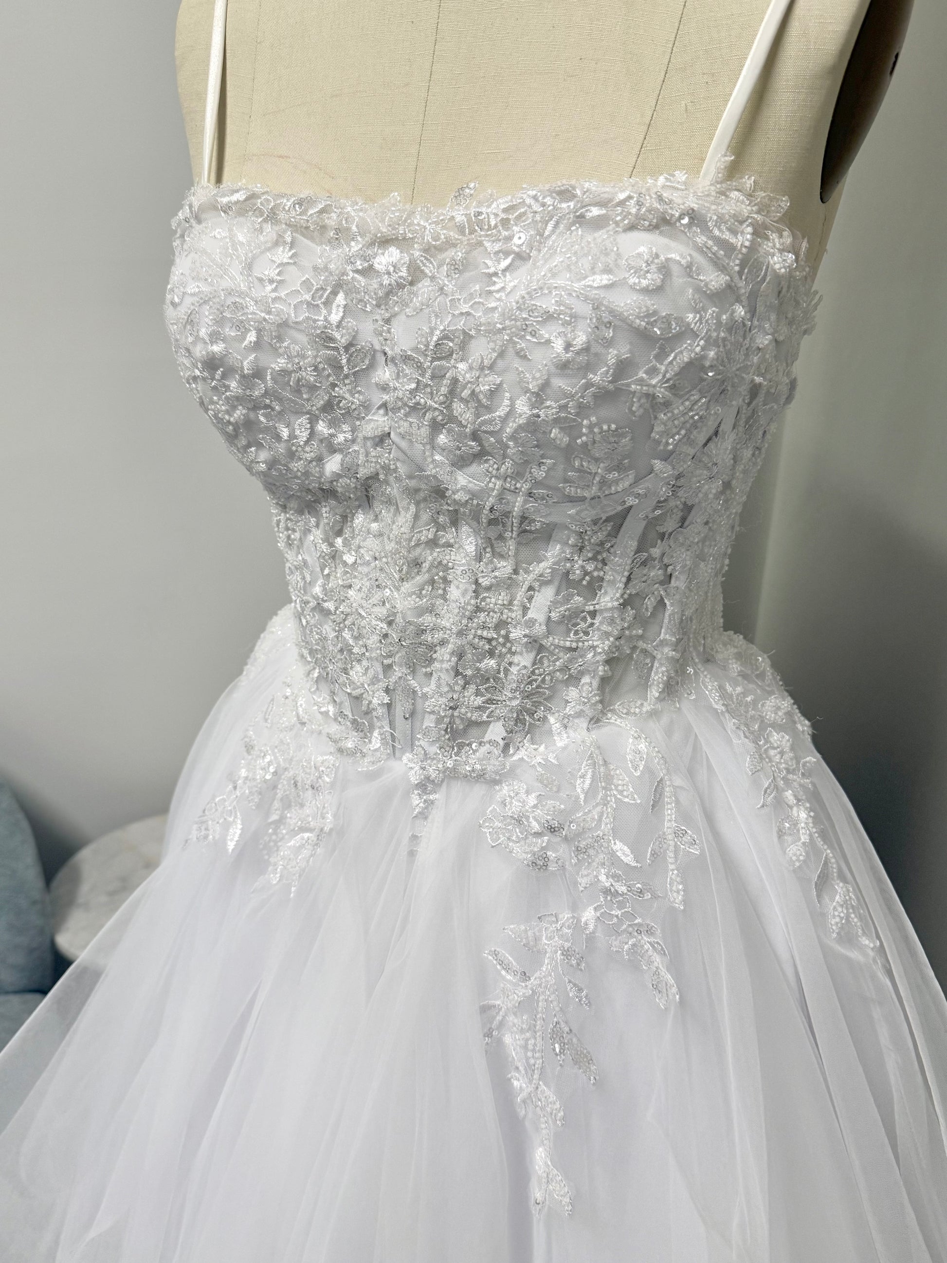 Elegant white strapless Mary lace debutante dress with structured bodice and layered tulle skirt.