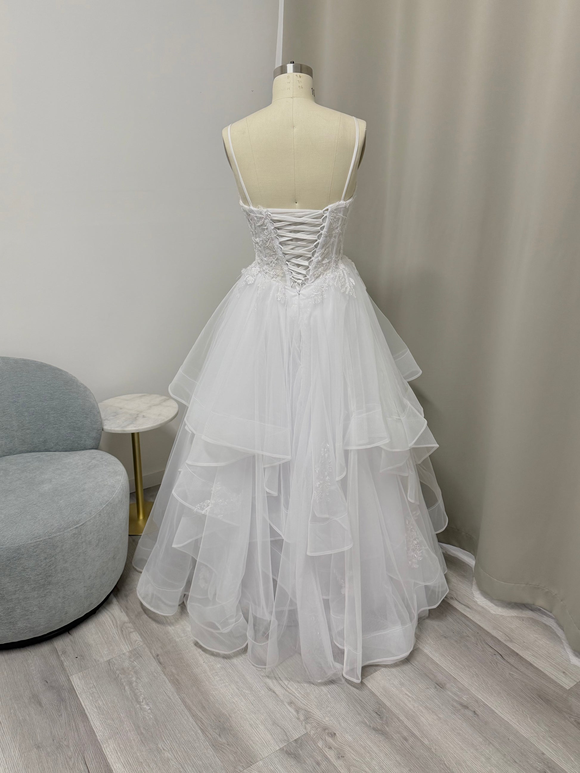 Back view of white strapless Mary lace debutante dress with corset-style back and flowing tulle skirt.