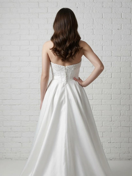 Back view of elegant white strapless satin debutante dress with sequined top and corset-style back