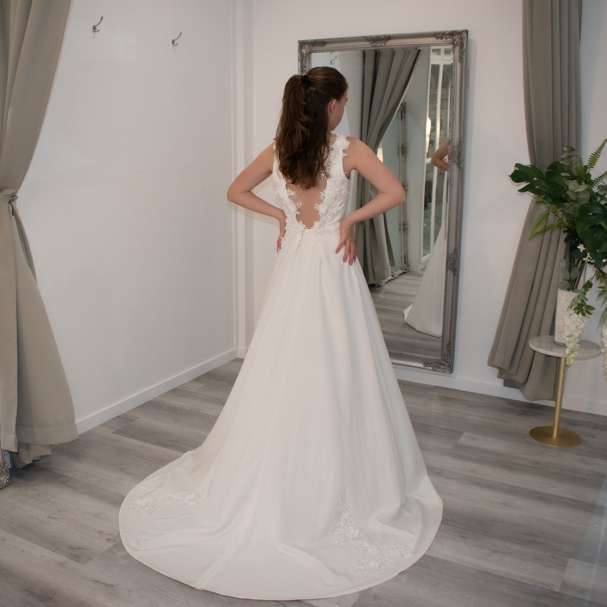 Bride donned in Aria wedding gown with a square neckline, illusion back adorned with 3-D lace, and a cascading chapel train.