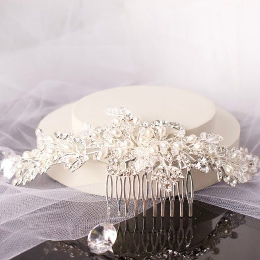 Stunning Polly Crystal Pearl Bridal Hair Comb, featuring clusters of shimmering pearls and diamantés on a chic silver base, ideal for enhancing bridal hairstyles with elegance and sparkle.