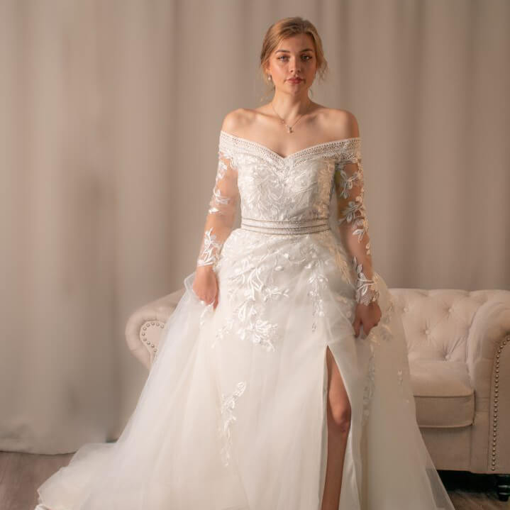 Diana off-shoulder lace ballgown wedding dress with heart V-shaped neckline and horsehair-edged hem.
