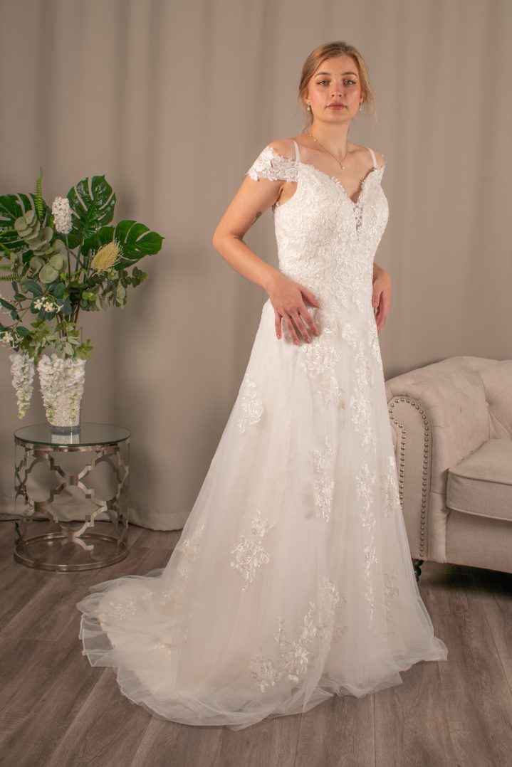 Danica off-shoulder lace wedding dress with V-neckline and fabric-covered button details.
