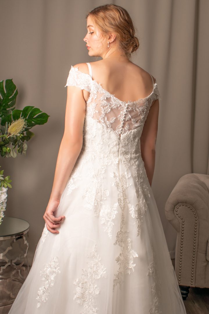 Danica off-shoulder lace wedding dress with V-neckline and fabric-covered button details.