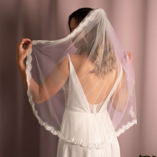 Elegant Elora Lace 1Tier Veil in soft tulle with lace edging, attached to a comb for a glamorous bridal look.
