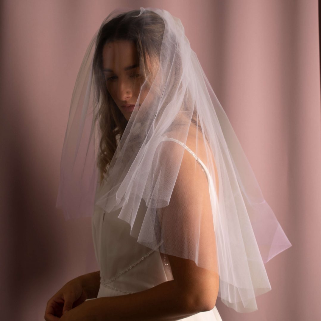 Elegant Serenity Bridal Veil in elbow-length American tulle, enhancing bridal hairstyle with volume and grace.