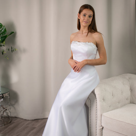 Strapless Brittany debutante dress with intricate beaded neckline and flowing A-line silhouette.
