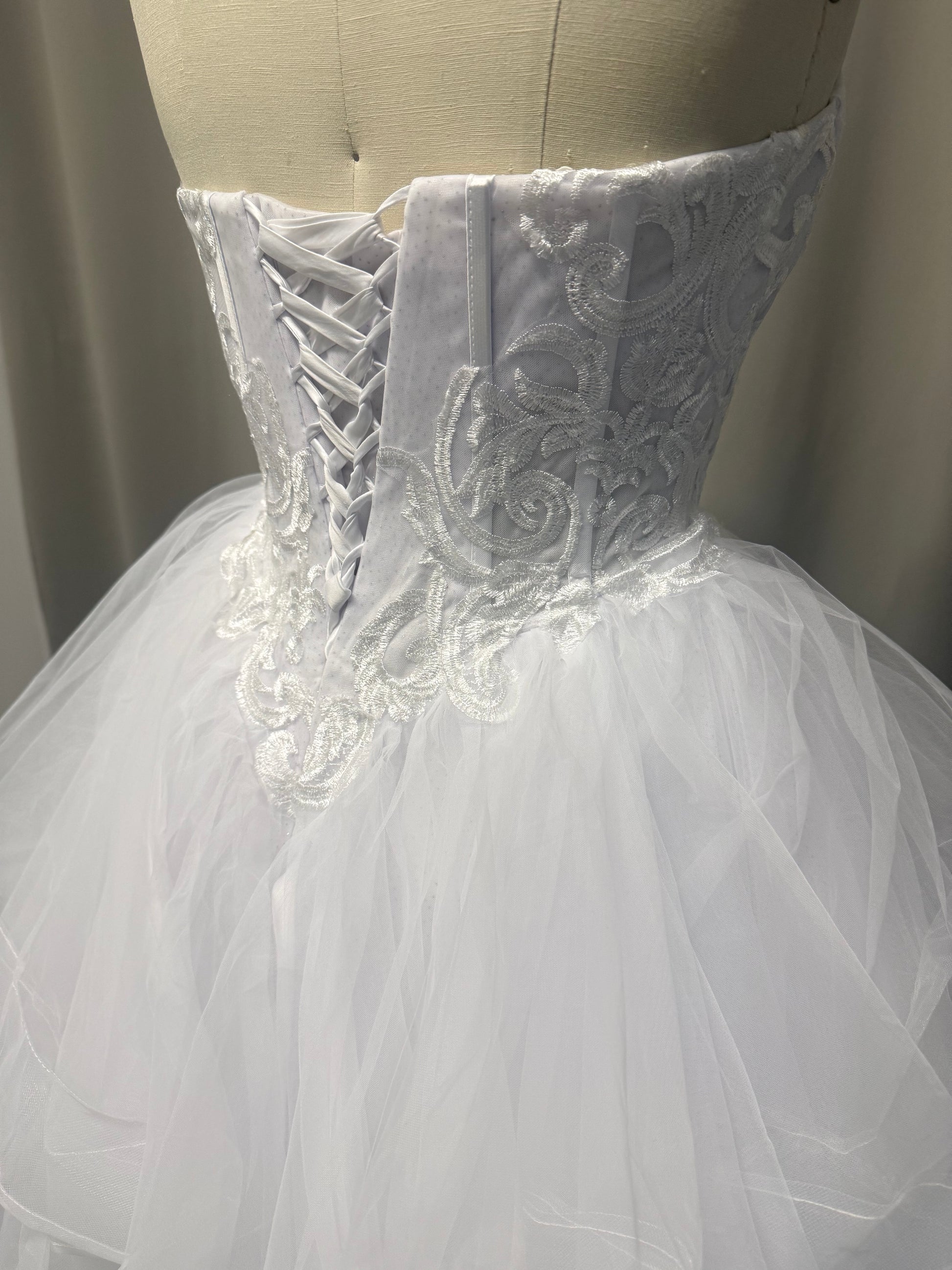 Deanna debutante ball dress back view showing lace-up corset, scroll embroidery and layered white tulle skirt