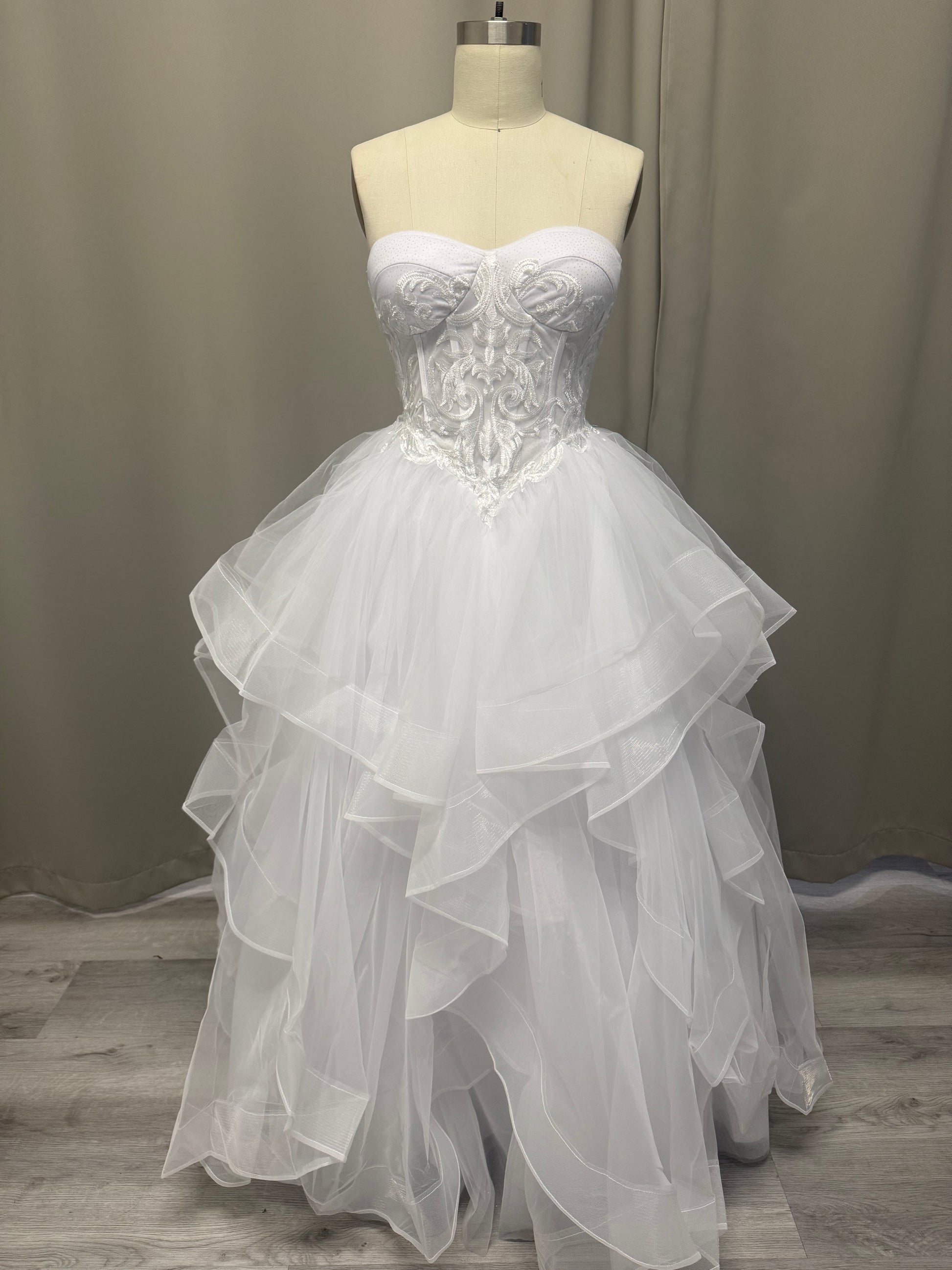 Deanna white strapless debutante ball dress, front view on mannequin with embroidered corset and layered tulle skirt