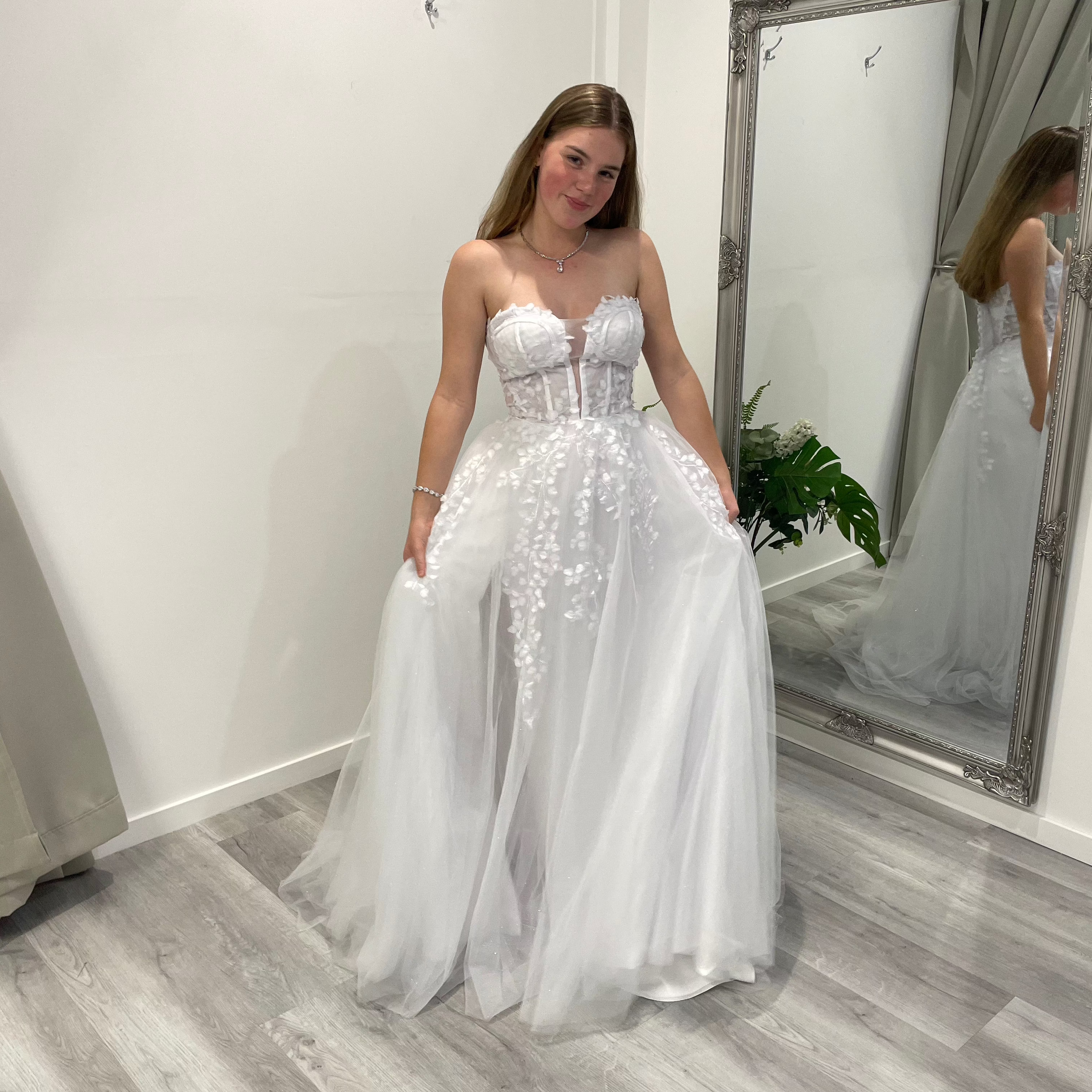 Close-up of white debutante dress featuring lace illusion bodice and beaded detailing