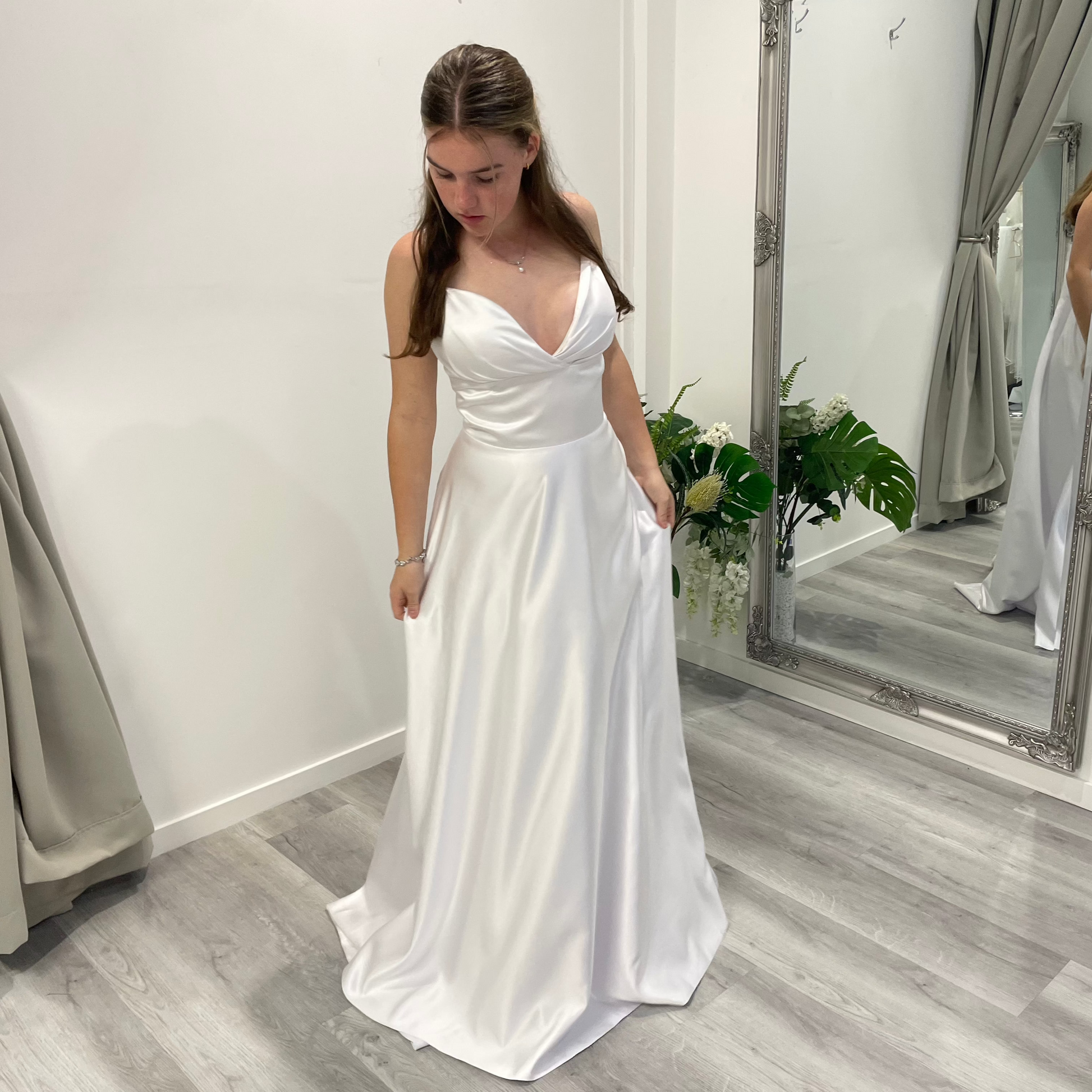 Serene Elegance deb dress in white satin with V-overlap neckline, slim straps, and A-line skirt