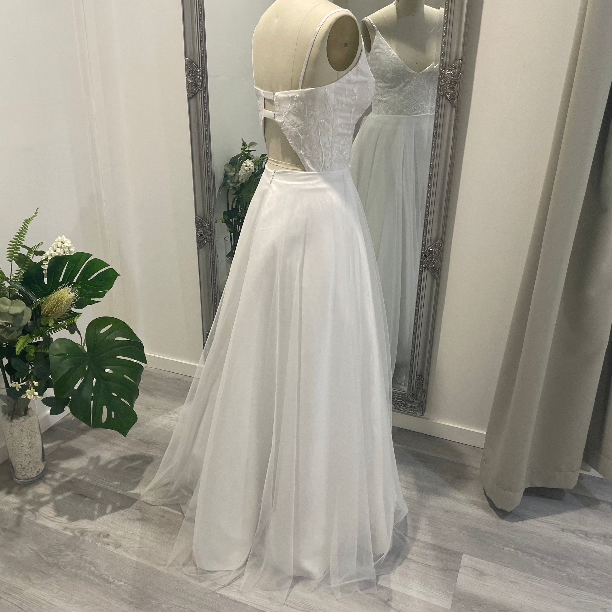 On mannequin back view of Valentina Lace Essence Deb Dress displaying the detailed lace corset bodice with a structured yet elegant fit, designed for a graceful back profile.