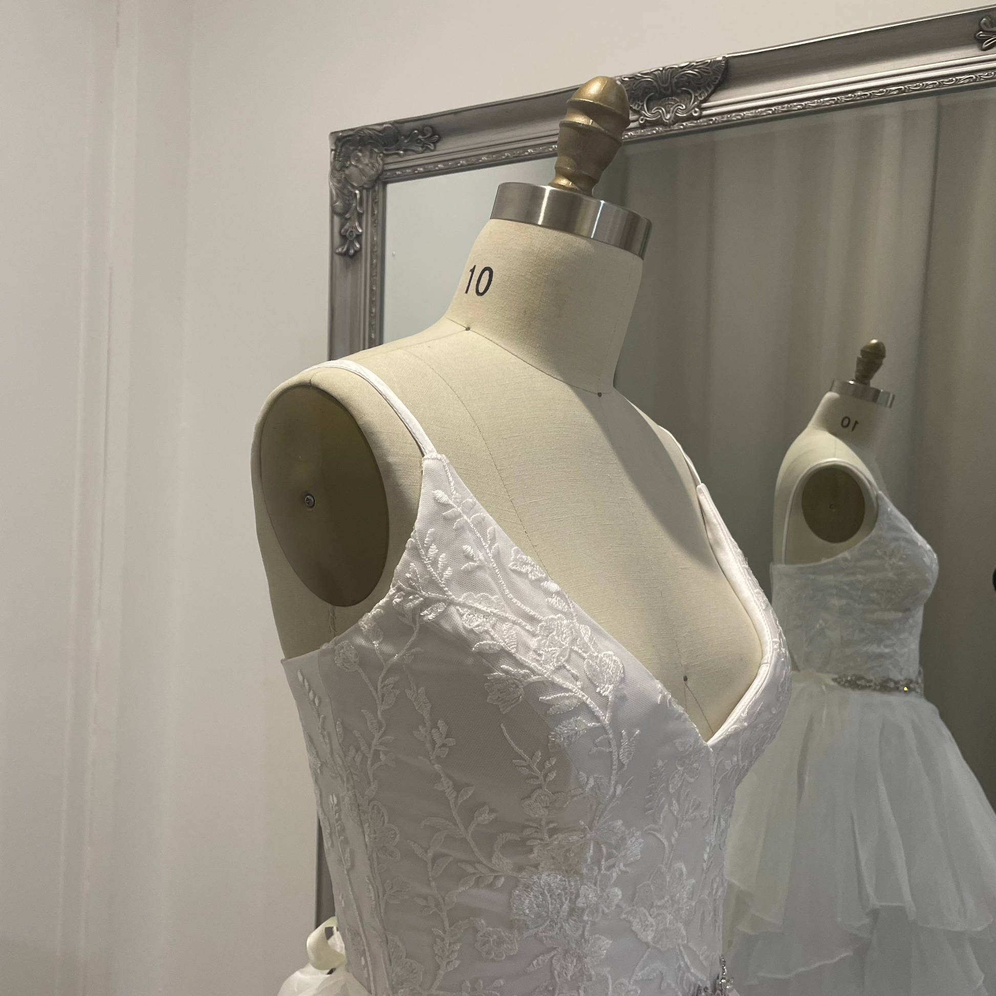 On mannequin front view of Valentina Lace Essence Deb Dress showcasing the intricate lace bodice with a sweetheart neckline, offering a delicate, feminine design.