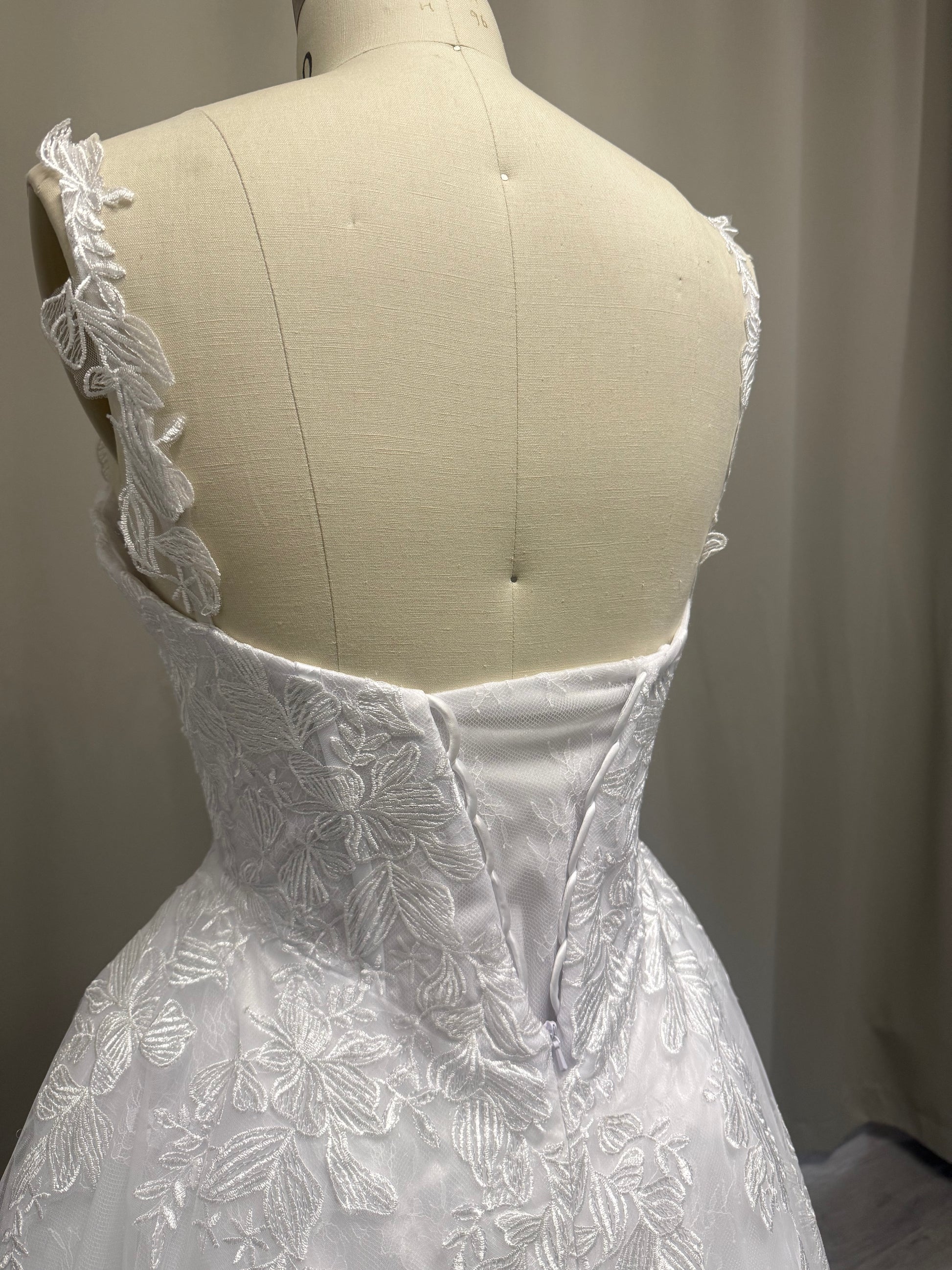 Deborah V1 debutante ball gown, back view showing structured lace bodice, strap detail and full white tulle skirt