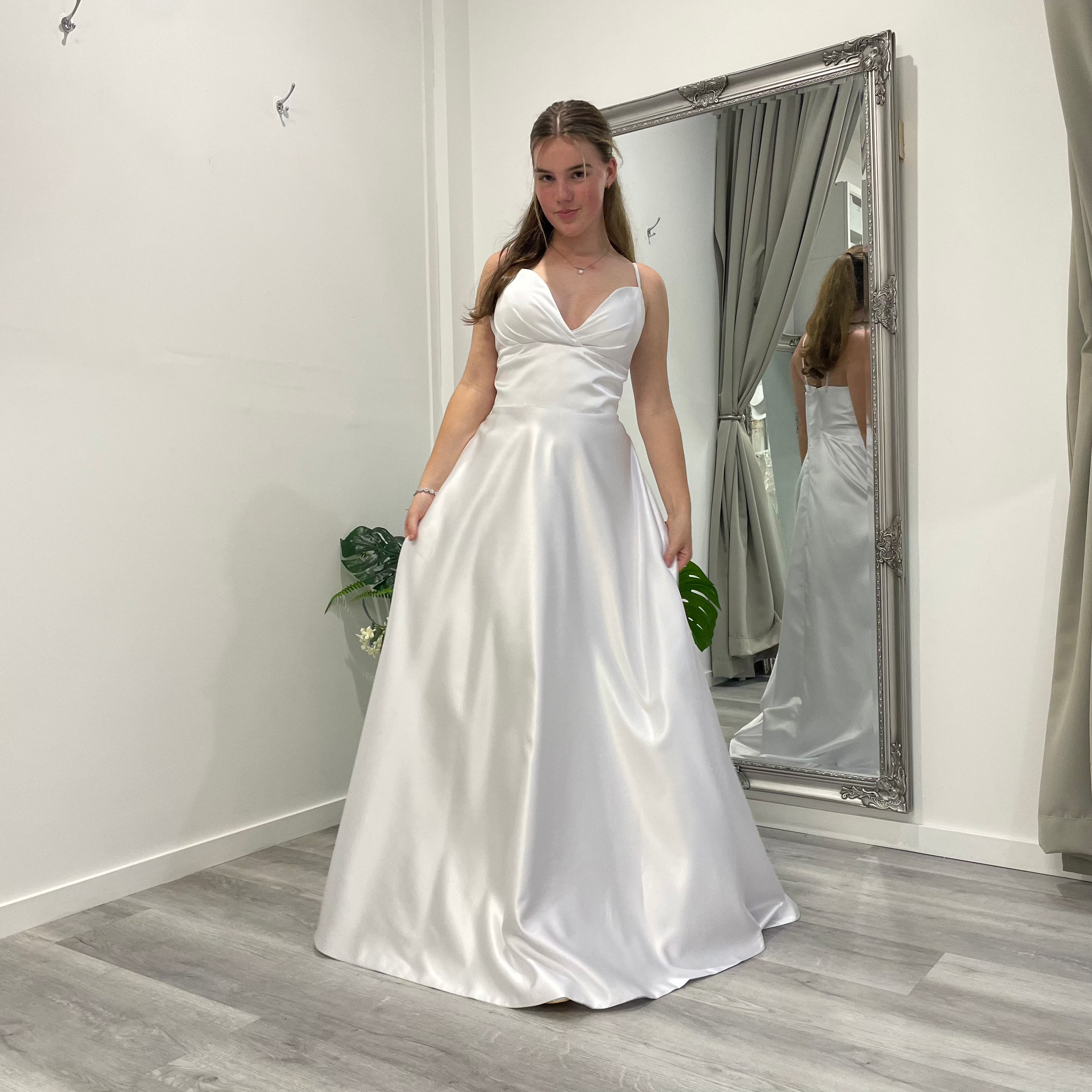Serene Elegance deb dress in white satin with V-overlap neckline, slim straps, and A-line skirt