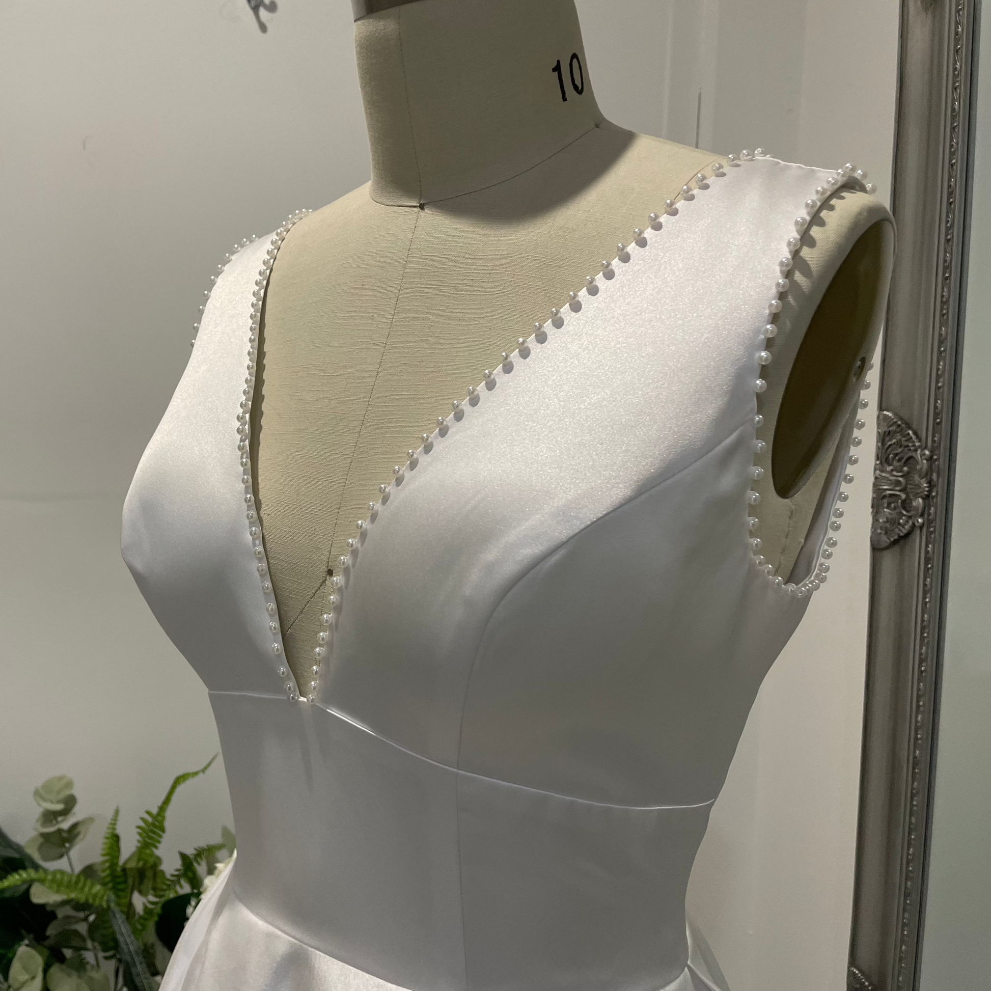 Liora Satin Whisper Deb Dress with pearl-trimmed V-neckline, satin A-line skirt, and slim straps