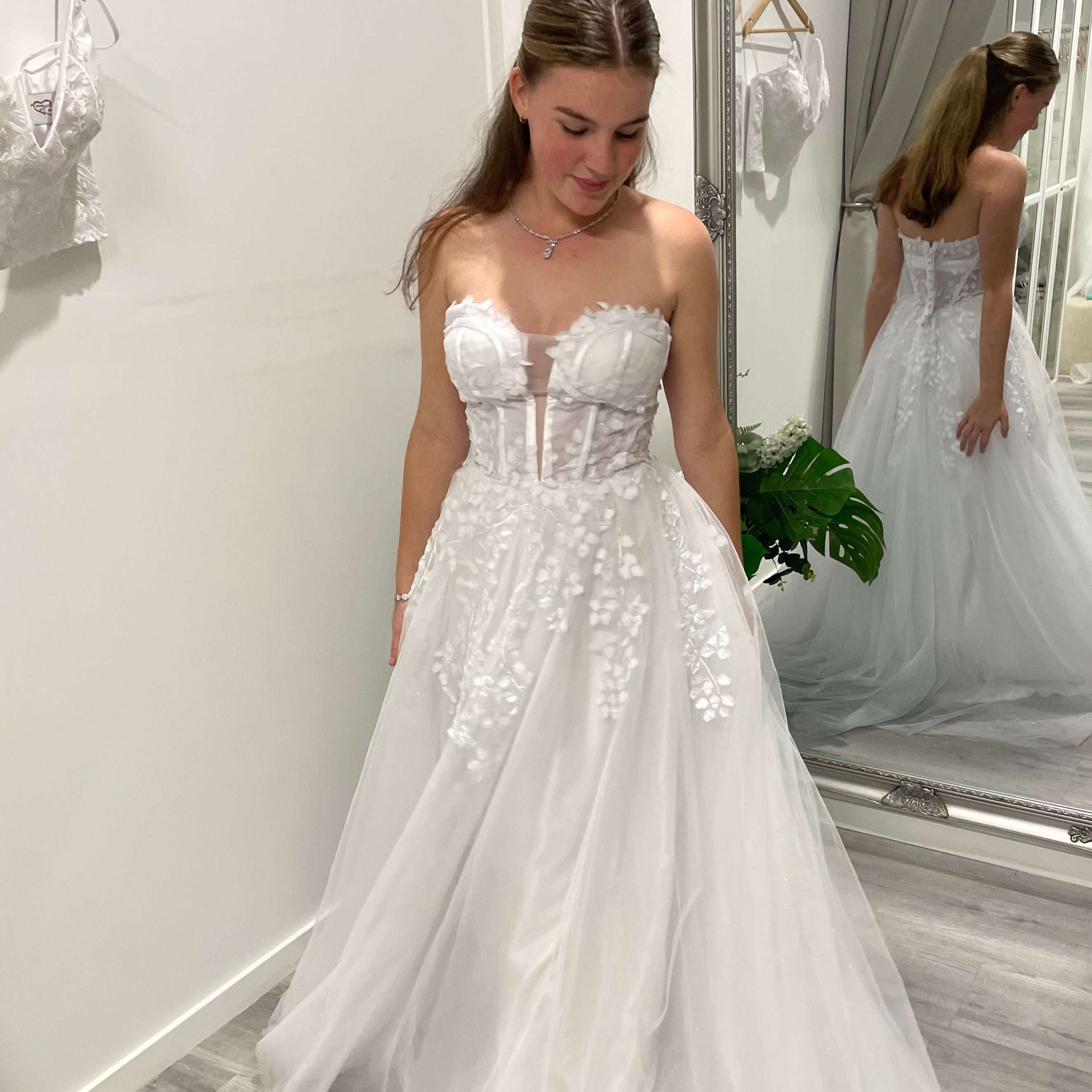 Close-up of white debutante dress featuring lace illusion bodice and beaded detailing