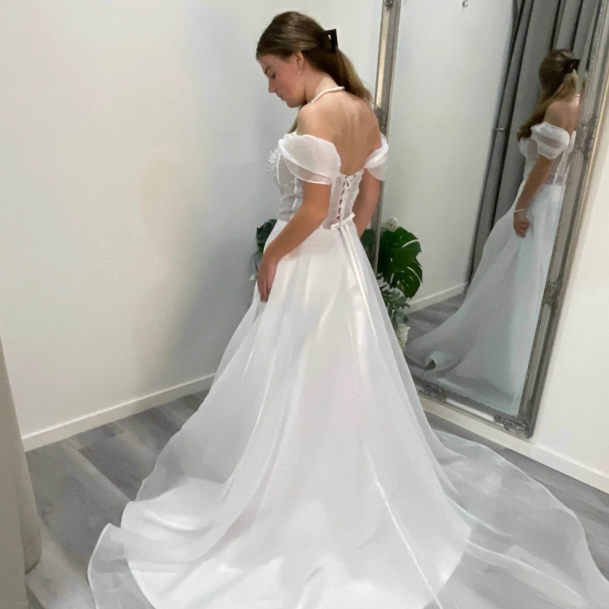 Back view of Diana Debutante Dress showcasing the intricate lace corset bodice with delicate beaded detailing and the soft, flowing organza A-line skirt.