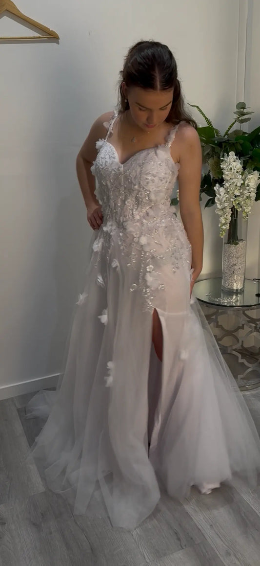 Woman looking down to the side of her dress showing it off.