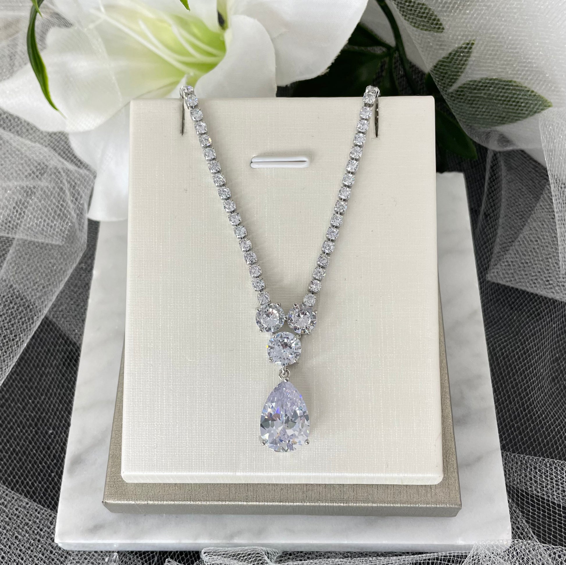 Dayna Diamanté Bridal Wedding Necklace:  "Close-up of the Dayna Diamanté Bridal Wedding Necklace, featuring a delicate chain adorned with round Diamontes and a sparkling centerpiece consisting of three large Diamantés and a teardrop pendant."