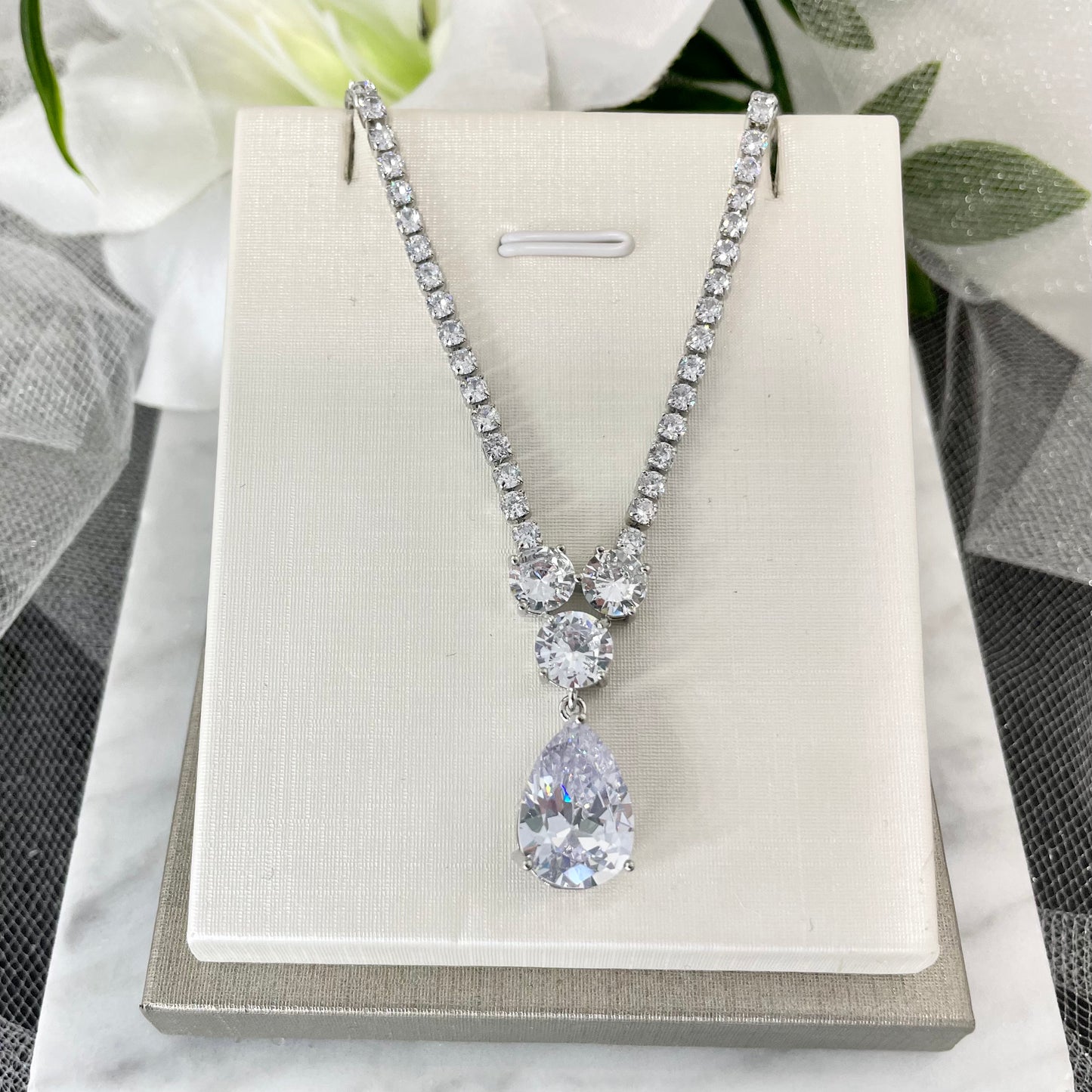 Dayna Diamanté Bridal Wedding Necklace: "Close-up of the Dayna Diamanté Bridal Wedding Necklace, featuring a delicate chain adorned with round Diamontes and a sparkling centerpiece consisting of three large Diamantés and a teardrop pendant."