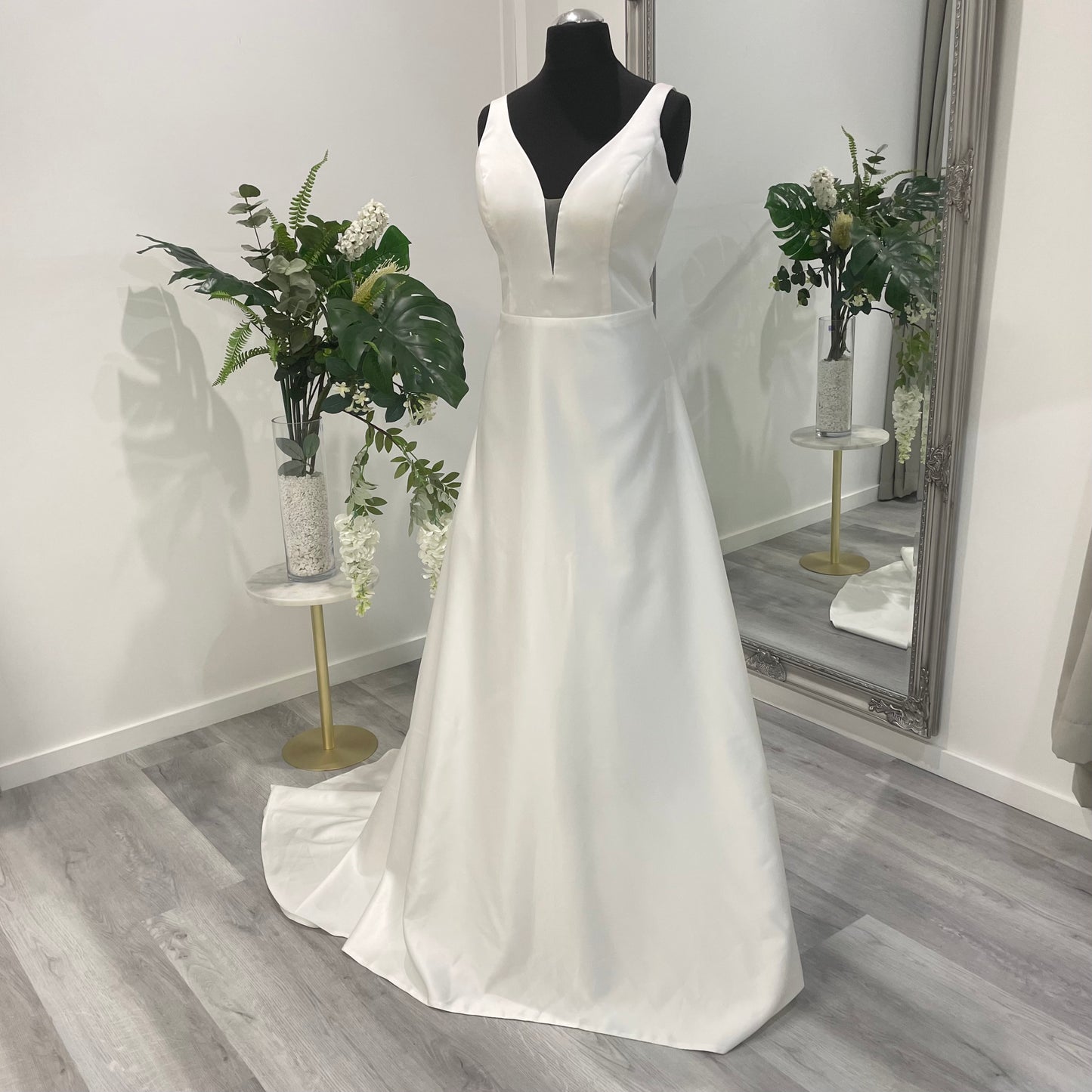Sophisticated Daisy Wedding Gown with a deep V-neckline, displayed in Divine Bridal salon.