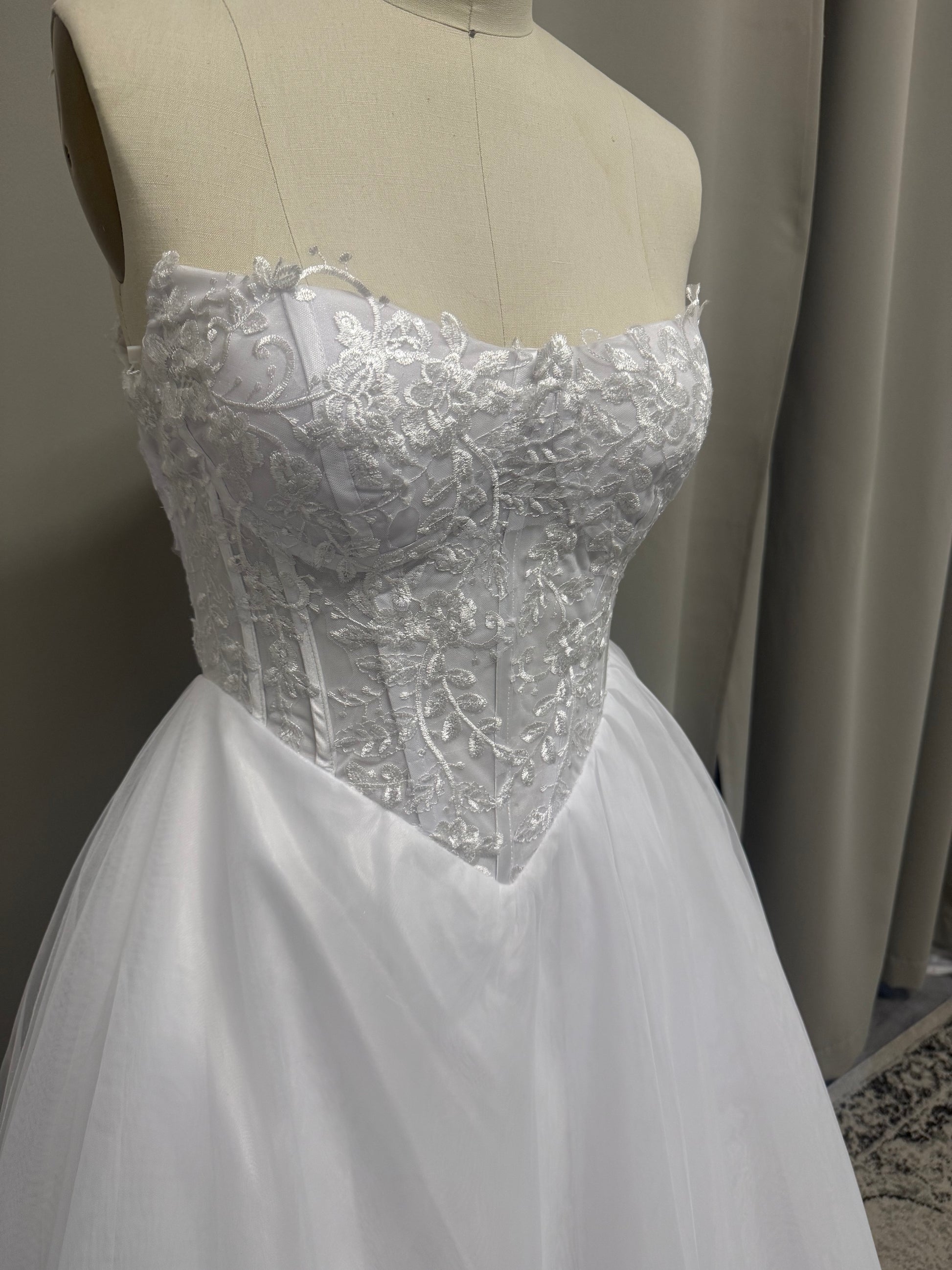 Close-up of Leona V1 embroidered corset debutante dress strapless sweetheart bodice with scroll lace embroidery