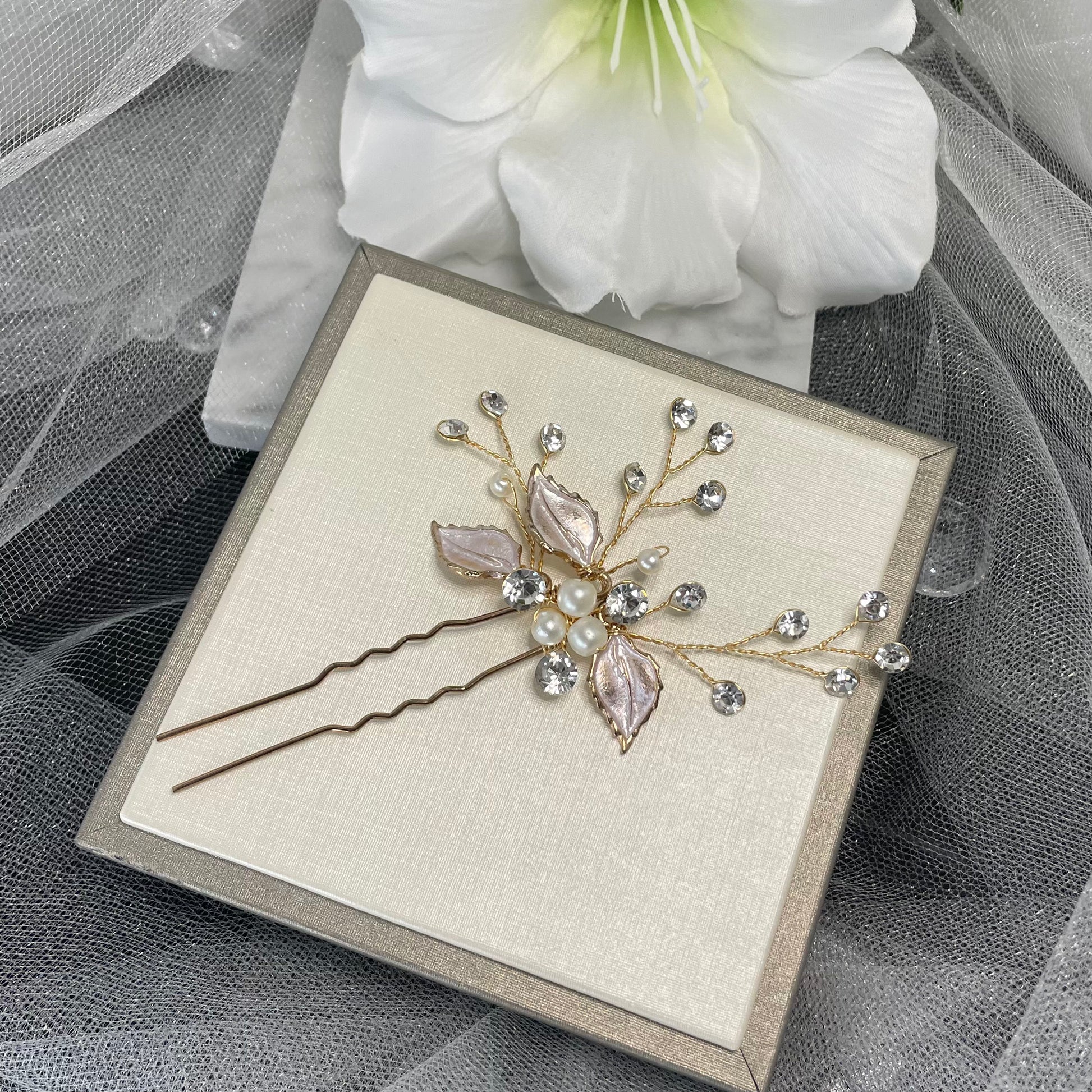 Stunning Megan Hairpin with three-leaf design, adorned with pearls and crystals, set on beautiful goldish and rosegold wire, perfect for adding elegance to wedding hairstyles.